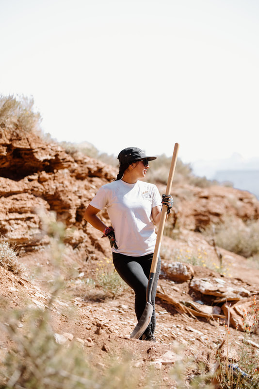 Mountain bike rider Samantha Soriano trail building with a shovel in her hand in the desert