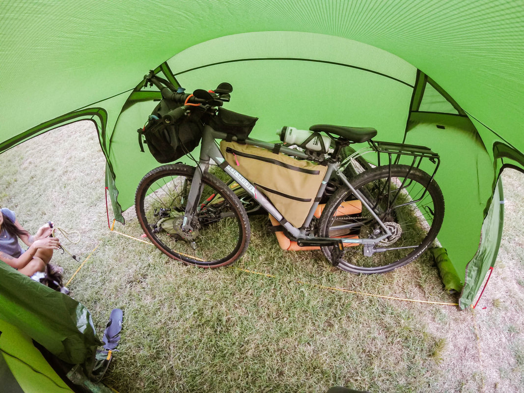 PictureNatureHike Opalus4 four person tent set up on a bikepacking trip. The vestibule fit both our bikes undercover.
